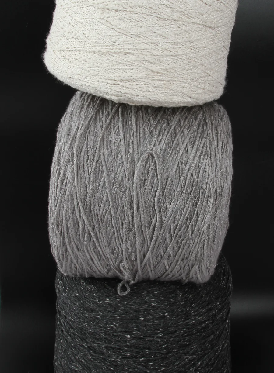 White, grey and black textured yarn cones in a client-supplied photograph